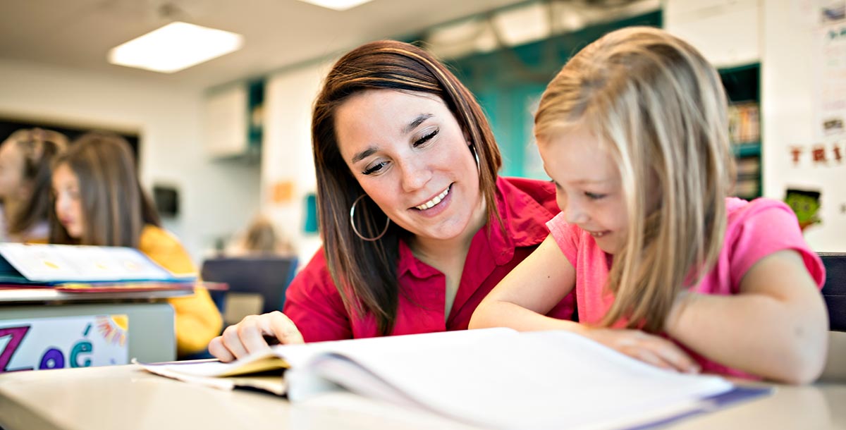 Girl reading with her teacher